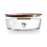WoodWick White Teak ellipse candle with warm glow for cozy evenings.