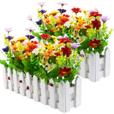 XONOR mixed color daisies in a picket fence pot brighten indoor spaces with lasting color.