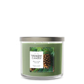 Yankee Candle Balsam and Cedar jar glows warmly, filling room with woodland fragrance.