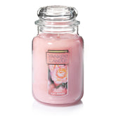 Yankee Candle Fresh Cut Roses 22oz jar with vibrant pink wax enhances ambiance.