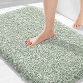 Yimobra light green and white bathroom rug on floor, plush and absorbent for quick water pickup.