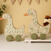 Yousoontic Silly Goose centerpiece with green foliage enhances 1st birthday decor.