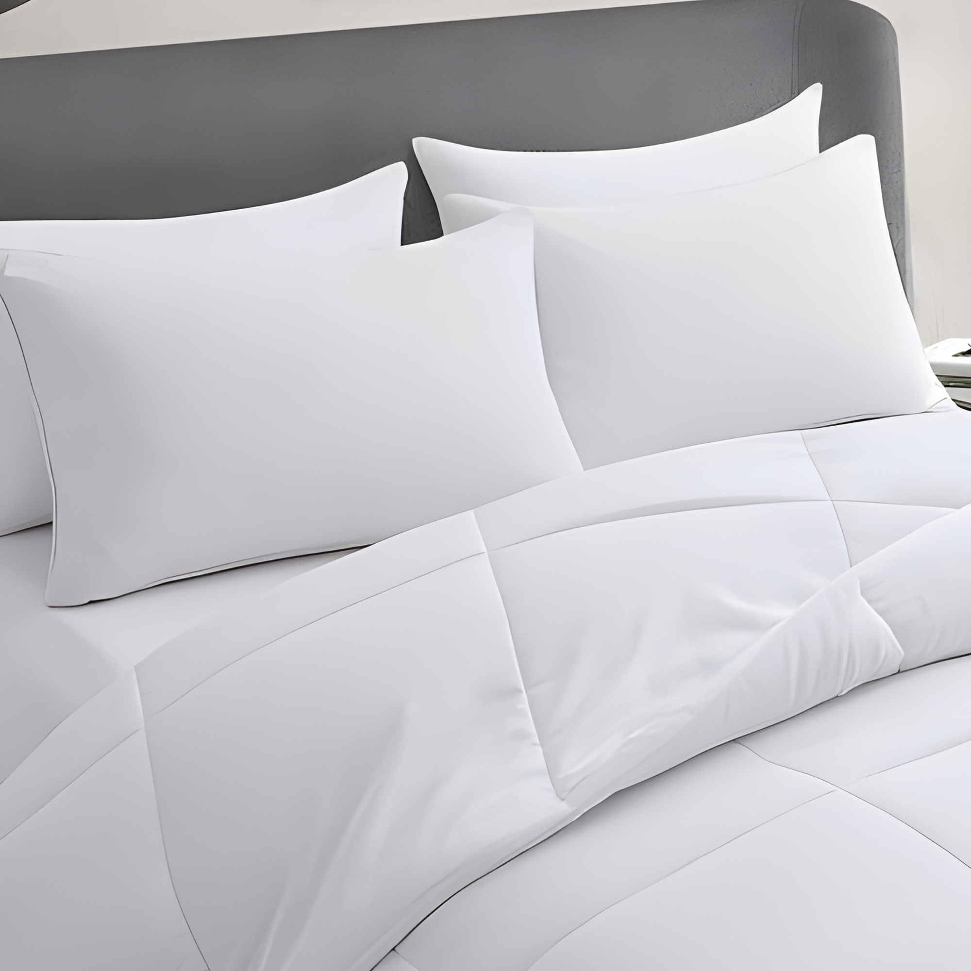 Acteb four-pack pillows stacked on bed demonstrate even loft for head and neck comfort.