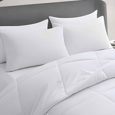 Acteb four-pack pillows stacked on bed demonstrate even loft for head and neck comfort.