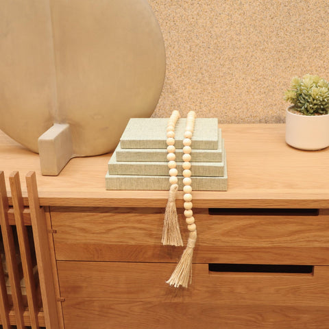 Neutral sage tone decorative books on a shelf complementing interior decor