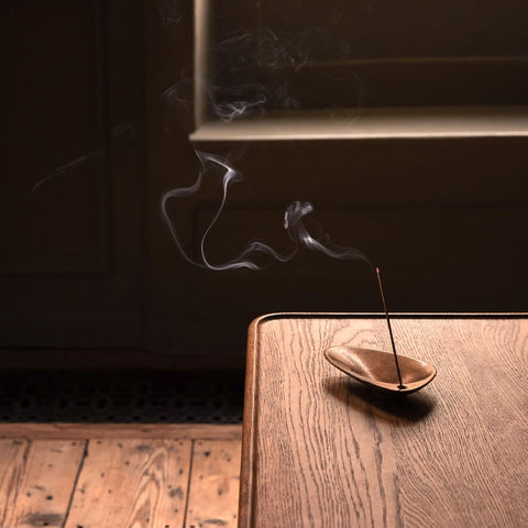 Aesop Kagerou incense smoke rising vertically with warm earth tones.
