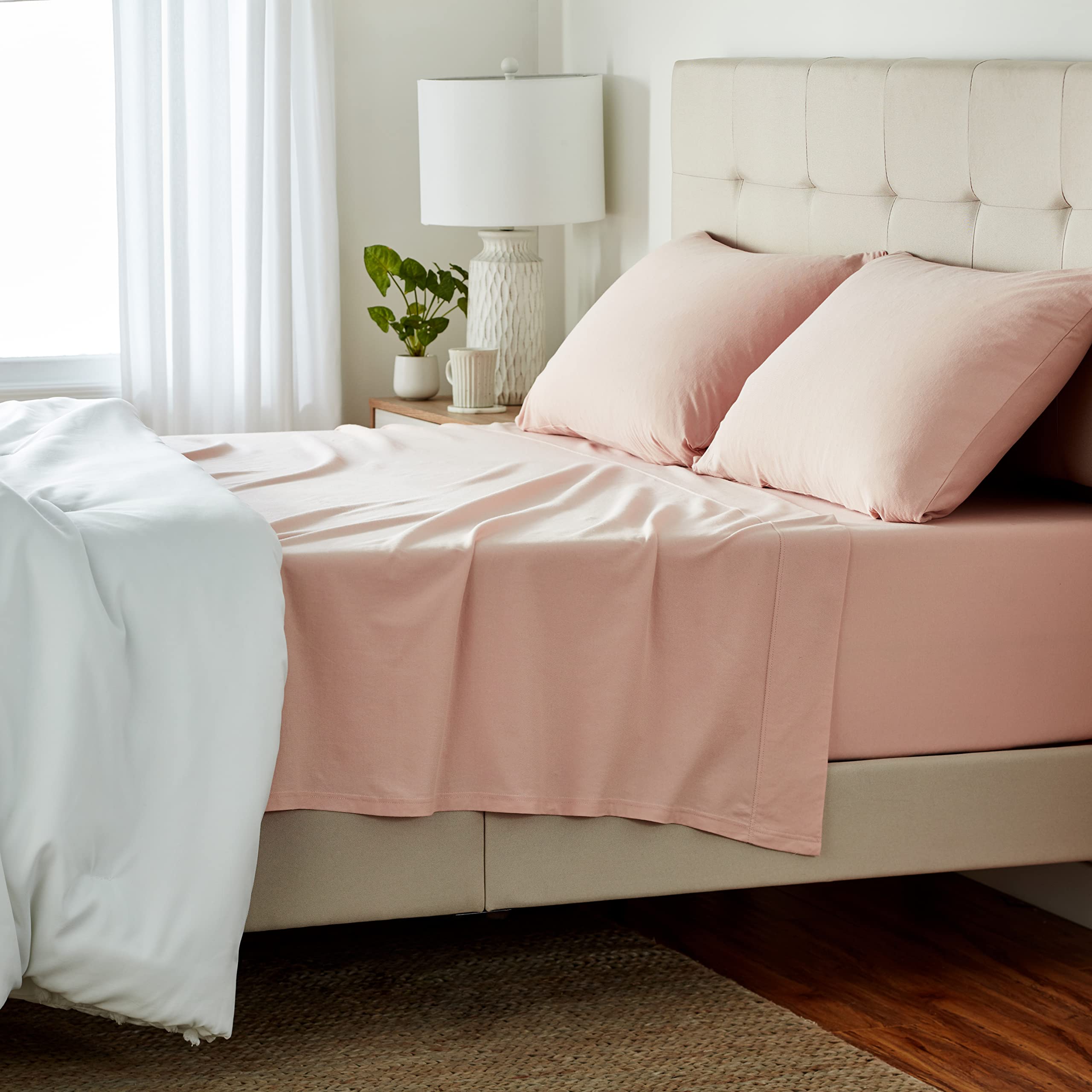Amazon Basics breathable cotton jersey bed sheet set in blush on a mattress with a soft feel