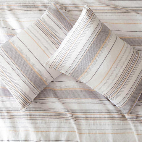 Amazon Basics comforter set on a bed with beige striped pattern for versatile decor.