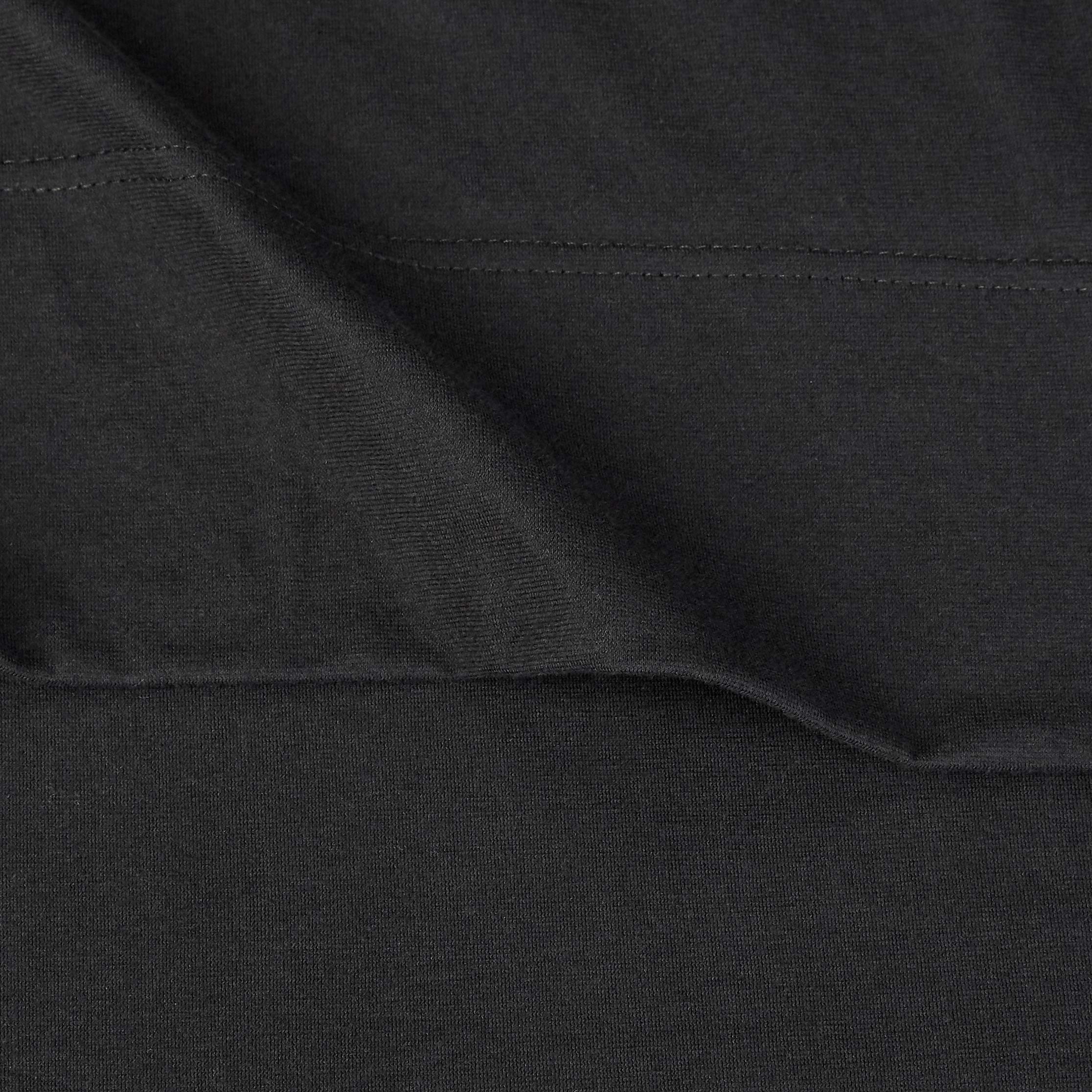 Amazon Basics fitted sheet pocket depth close-up illustrates secure fit up to 14 inches.