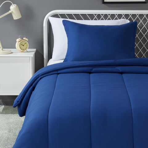 Amazon Basics kids comforter and navy pillow sham set on a bed for kid-friendly comfort.