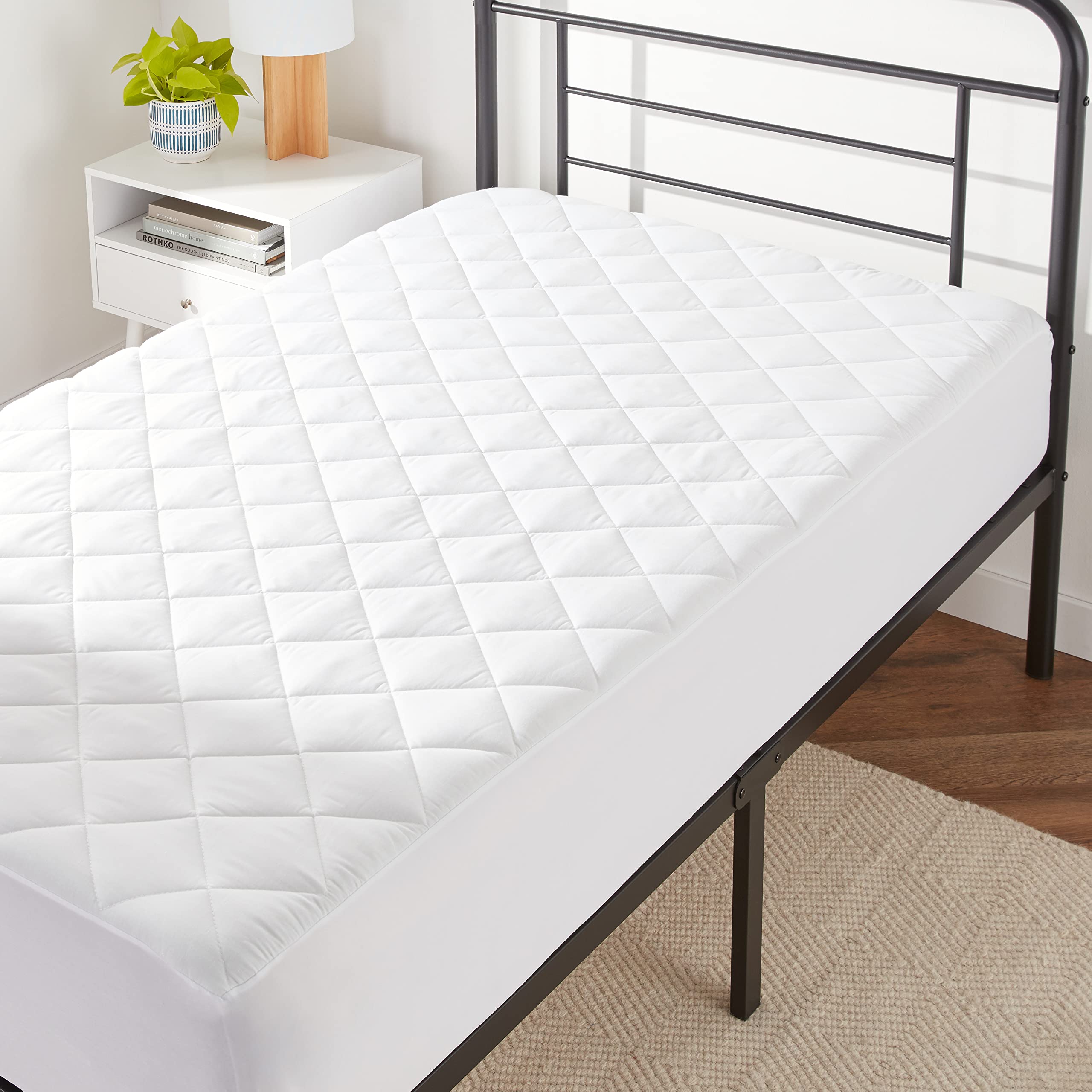 Amazon Basics hypoallergenic quilted topper pad on twin bed for added comfort