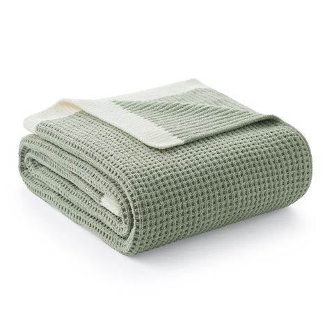 Amélie Home chenille waffle throw with soft touch draped over a sofa for cozy comfort.