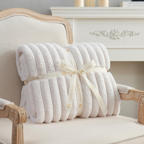 Amélie Home ivory blanket styled as a cozy gift idea.