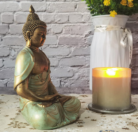 Angel Shine meditation decor statue pairs with plants and candles for relaxation.