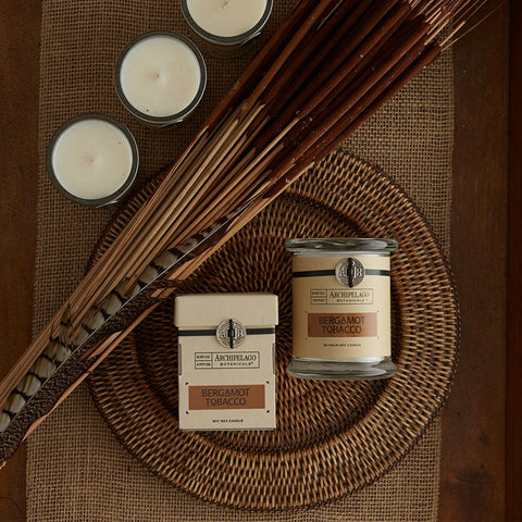 Archipelago Botanicals candle in a room setting, casting a warm, cozy glow.