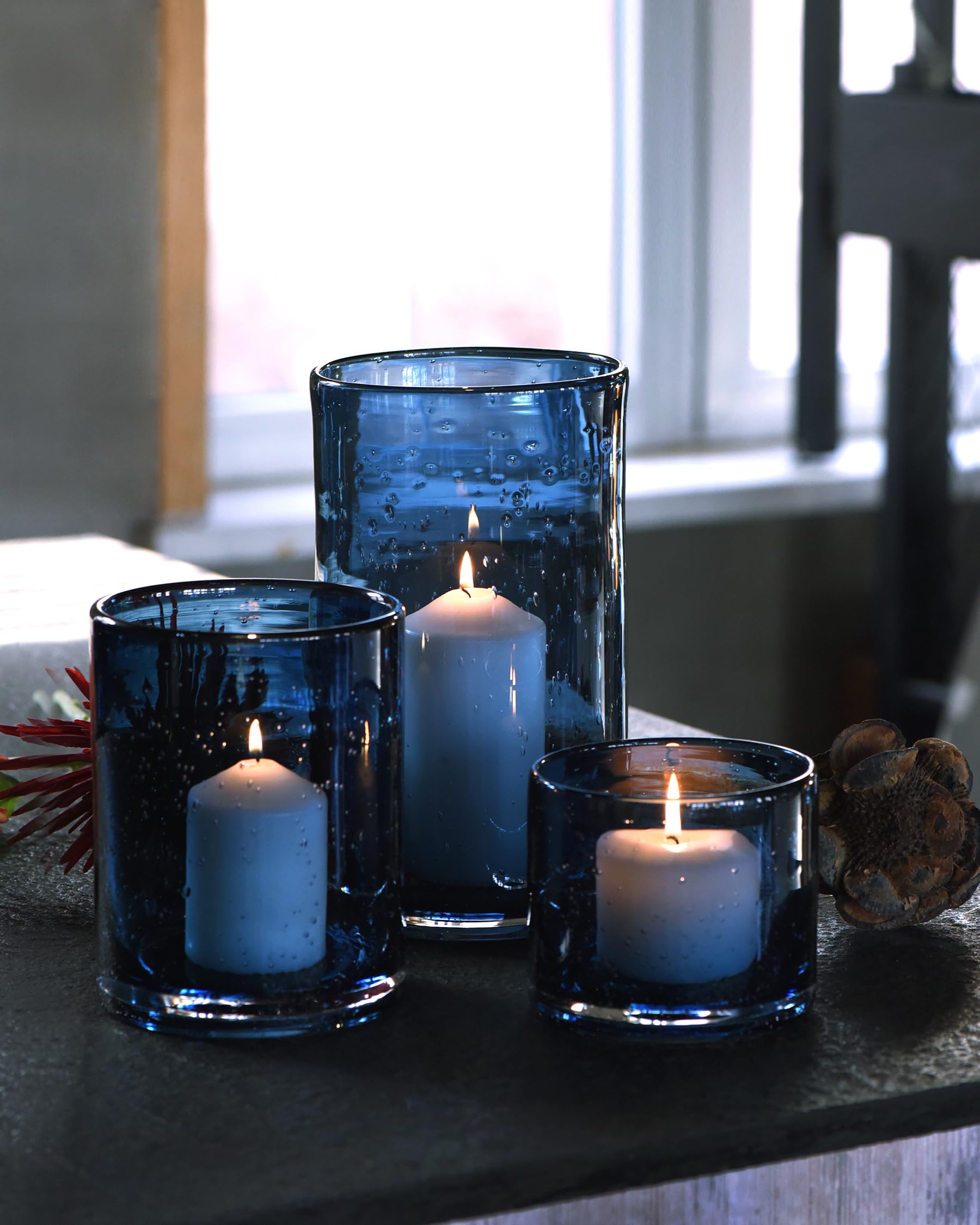 ARIAMOTION glass hurricane candle holder in blue seeded bubbles adds ambient dining room glow