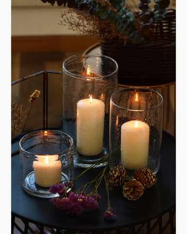 Seeded bubbles reflect light, creating cozy dining atmosphere with ARIAMOTION holders.