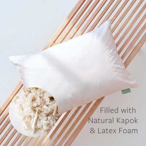Queen-size Avocado Organic Cotton Pillow resting on a neatly made bed.
