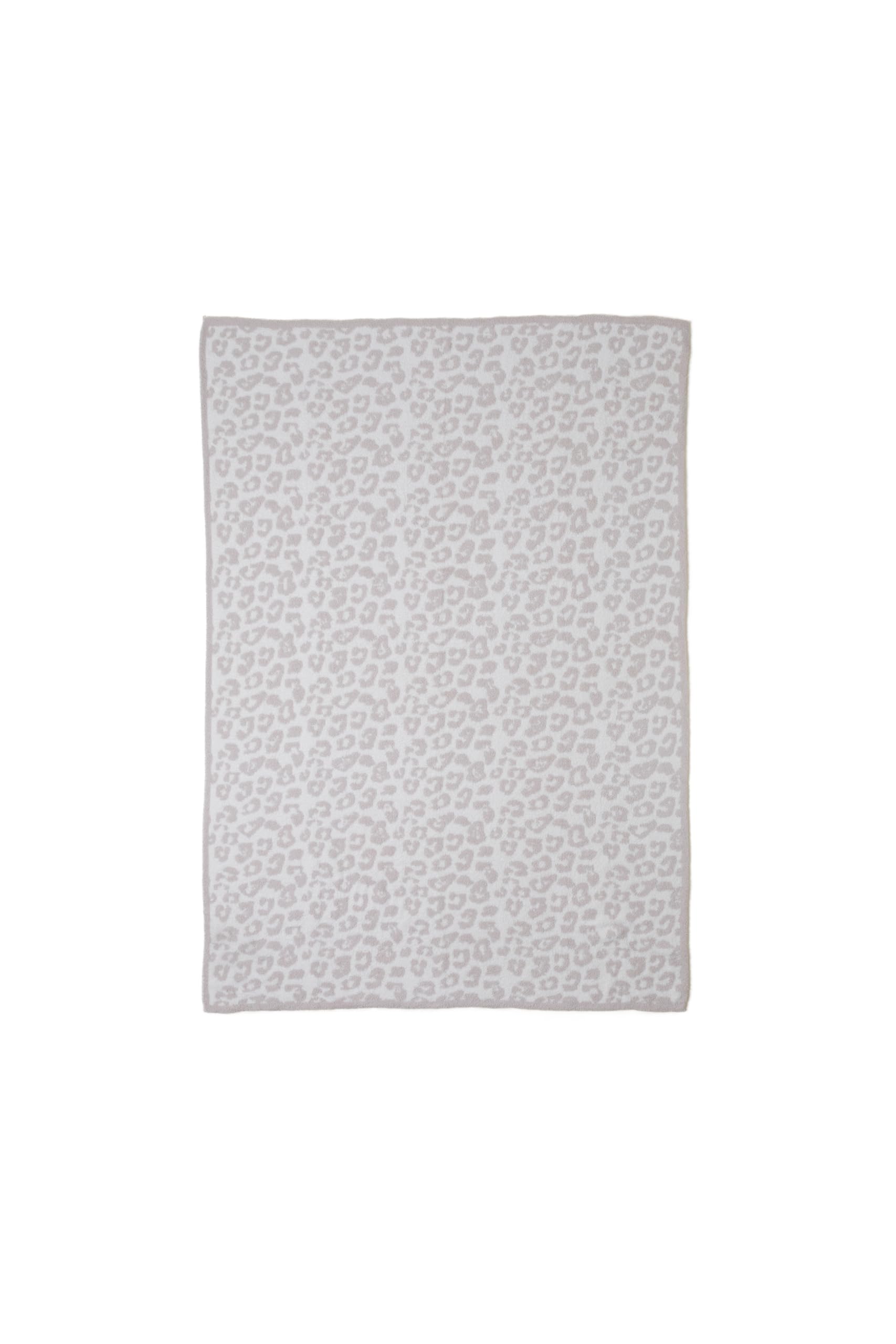 Barefoot Dreams CozyChic wild throw laid over a bed in neutral tones