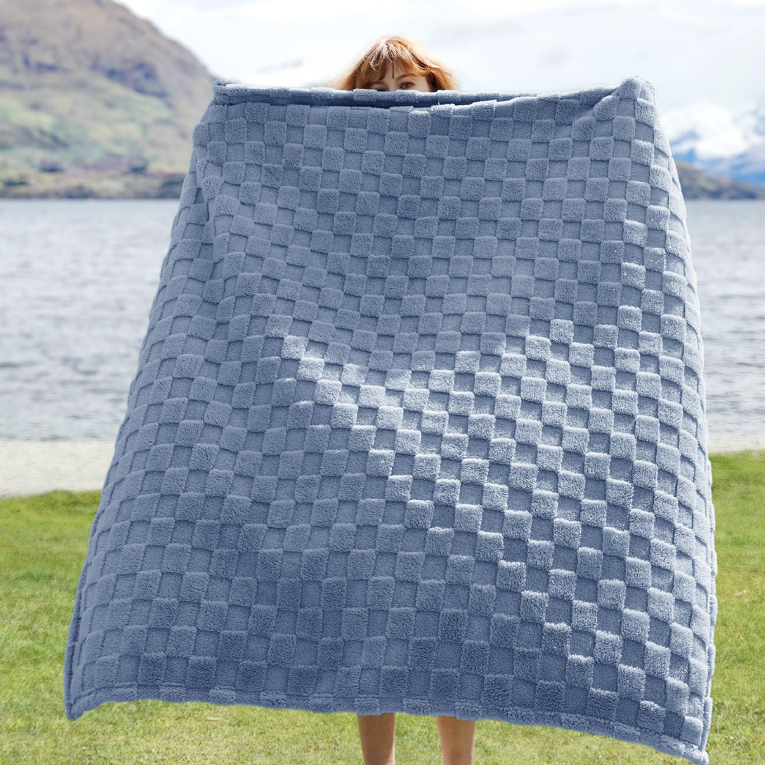 Bedsure GentleSoft Ashley Blue Throw folded on a couch adds lightweight warmth for snuggling.