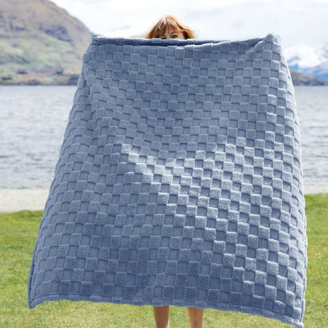 Bedsure GentleSoft Ashley Blue Throw folded on a couch adds lightweight warmth for snuggling.