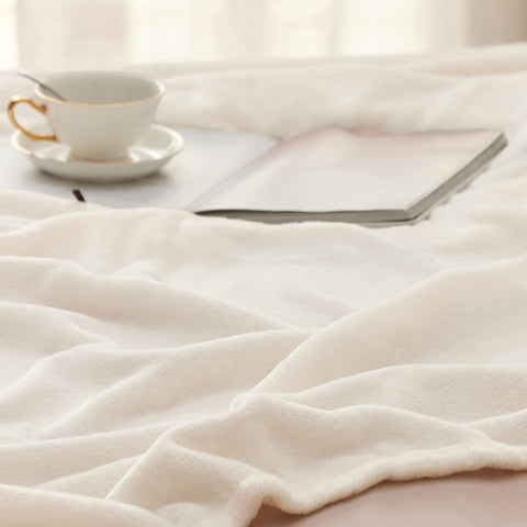 Bedsure GentleSoft blanket cream draped on sofa, providing lightweight warmth.