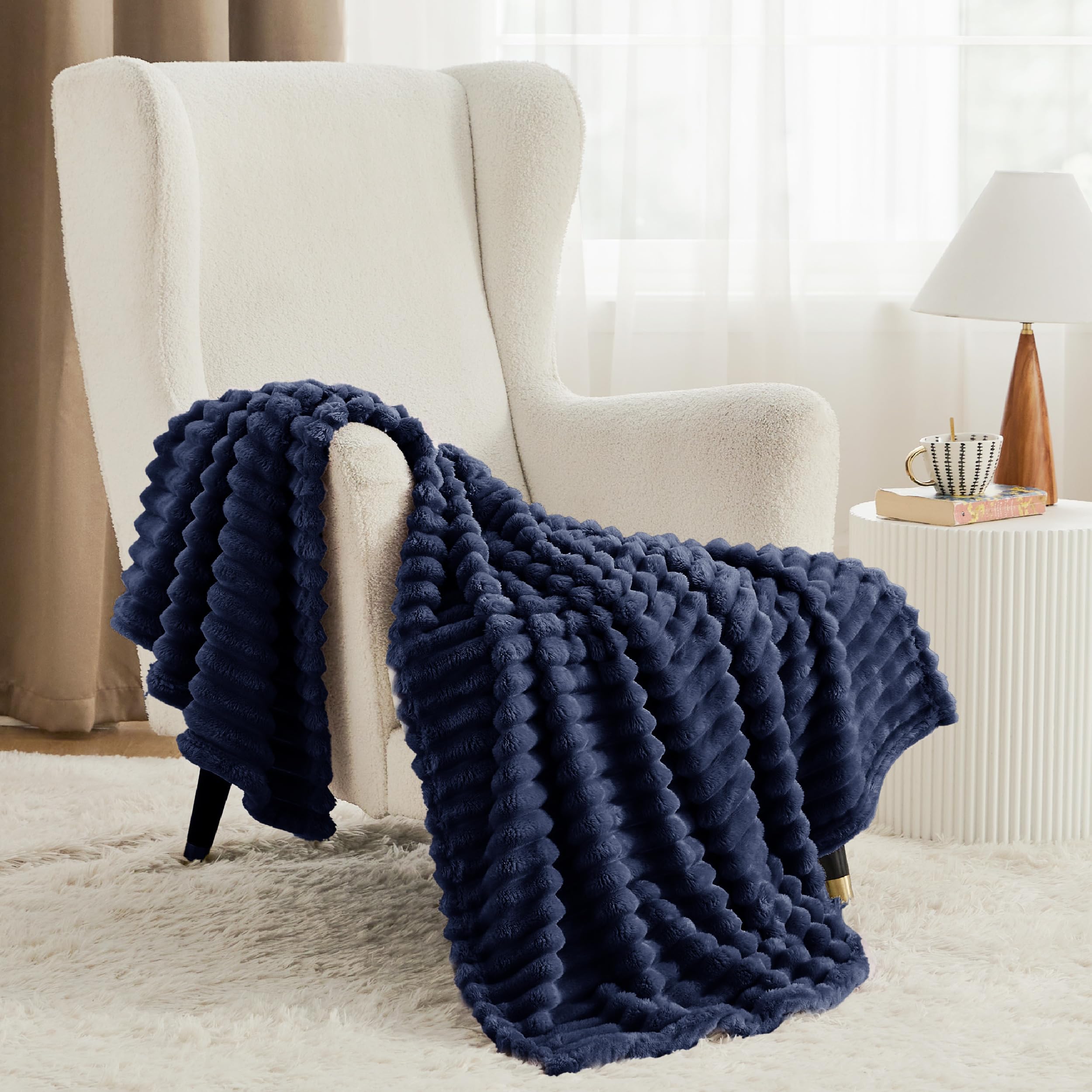 Bedsure GentleSoft navy blanket layered on bed adds lightweight warmth.