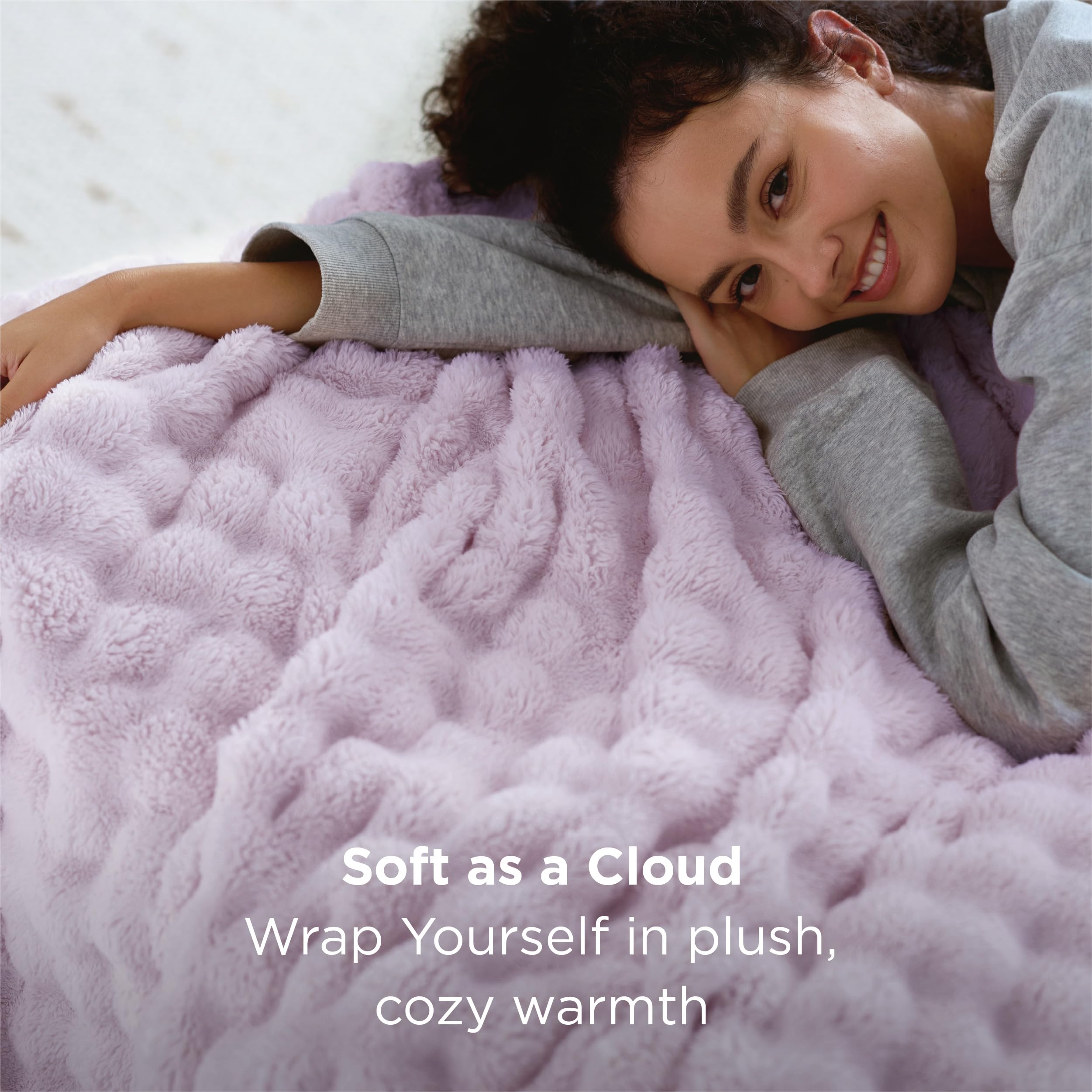 Bedsure GentleSoft purple throw on sofa demonstrates lightweight warmth for year‑round use.