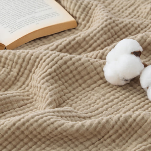 Bedsure Muslin Blanket 4-layer light brown folded neatly, ideal for cozy evenings.