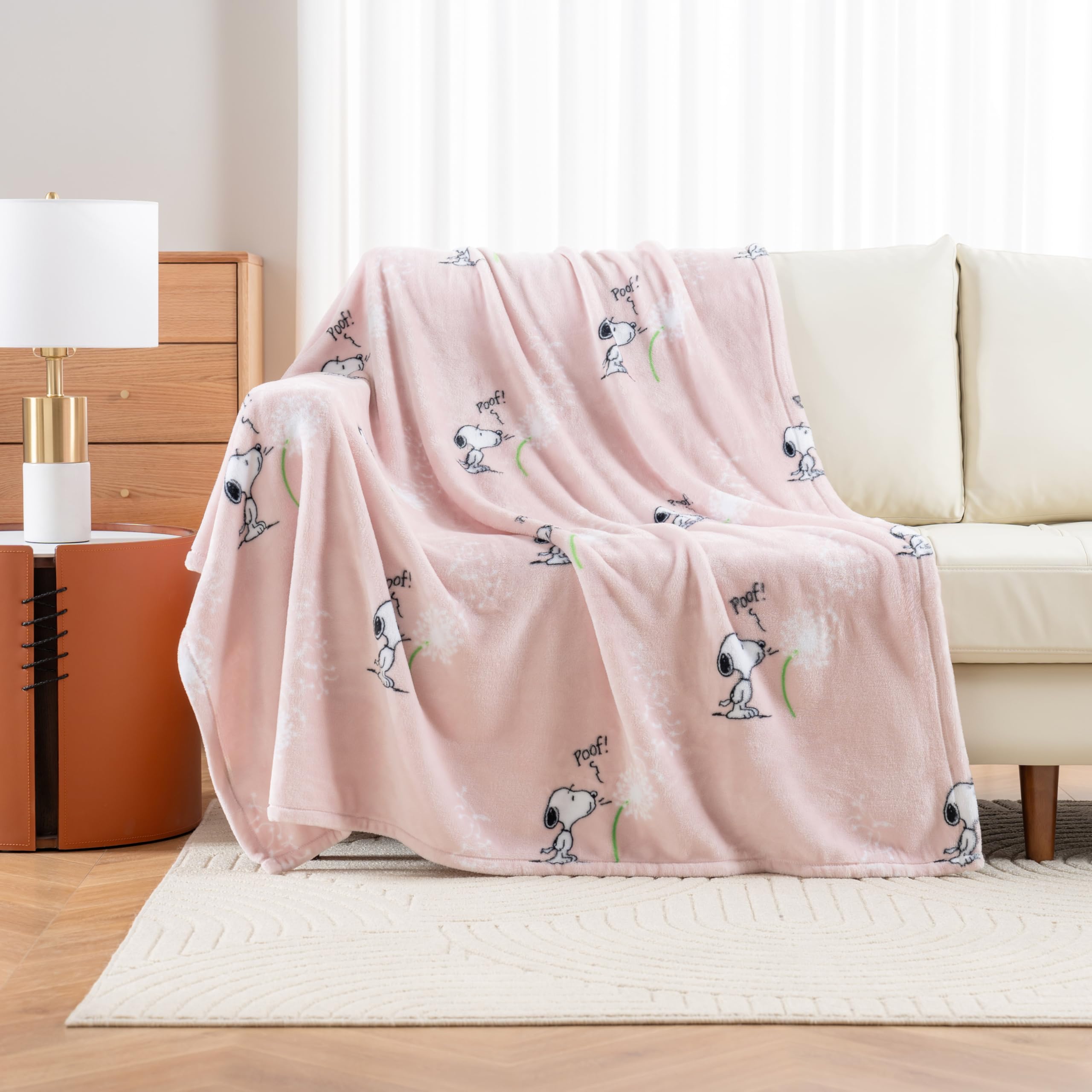 Berkshire Blanket Peanuts VelvetLoft Snoopy throw on couch highlighting soft warmth for year-round comfort.