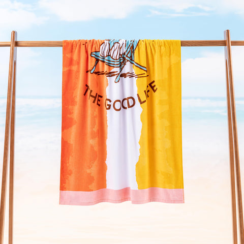 Berkshire Blanket Snoopy towel spread for sunbathing and family fun on sandy beach.
