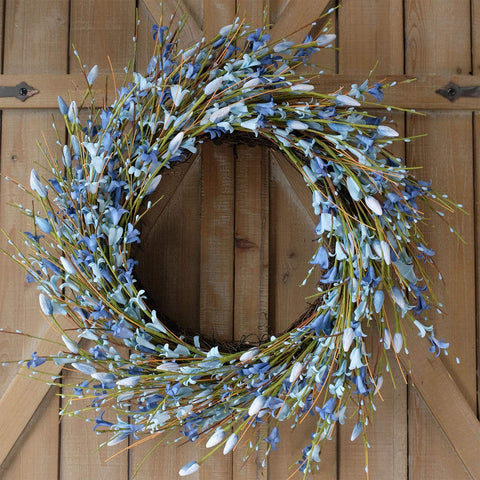 Bibelot Forsythia wreath brightens living room walls with vibrant blue.