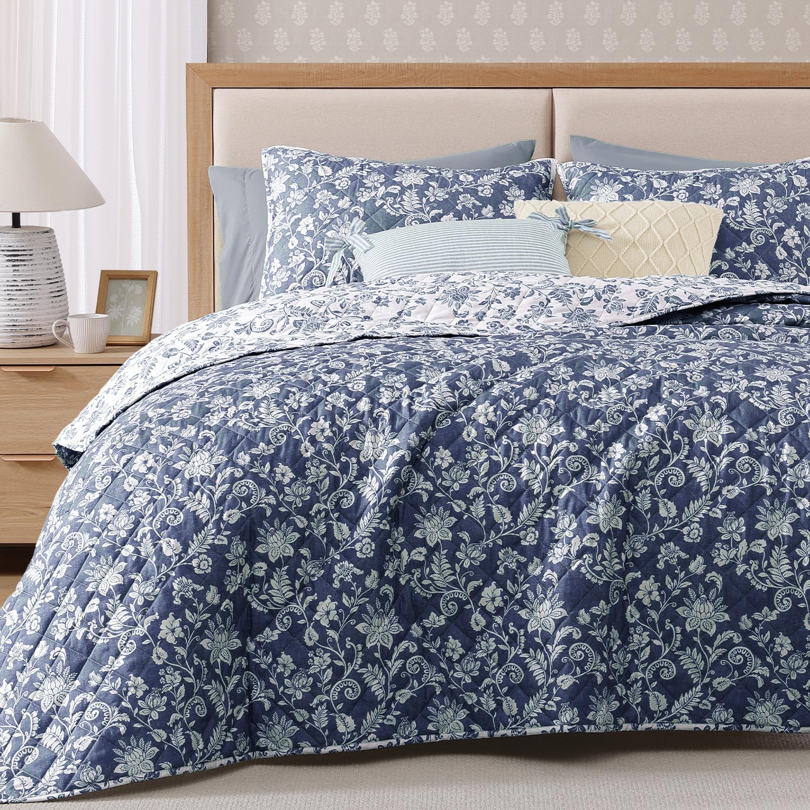 BLOOMHAVEN room scene shows the quilt enhancing the calming blue floral aesthetic.