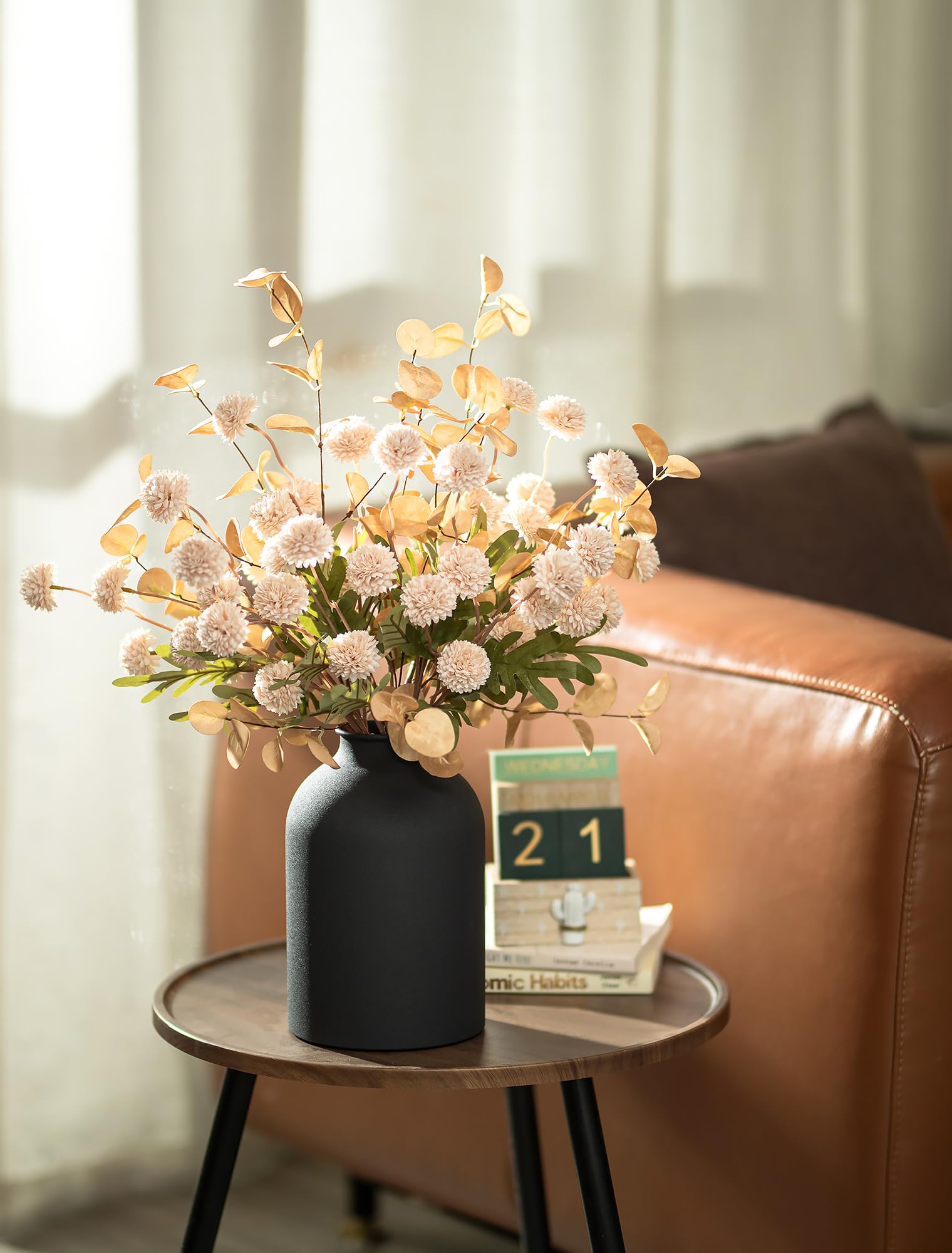 Matte black metal vase from BLOSMON complements beige tones.