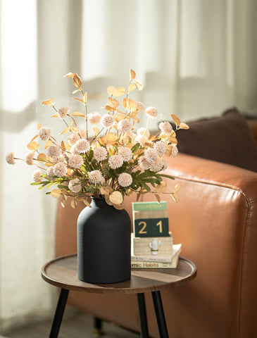Matte black metal vase from BLOSMON complements beige tones.