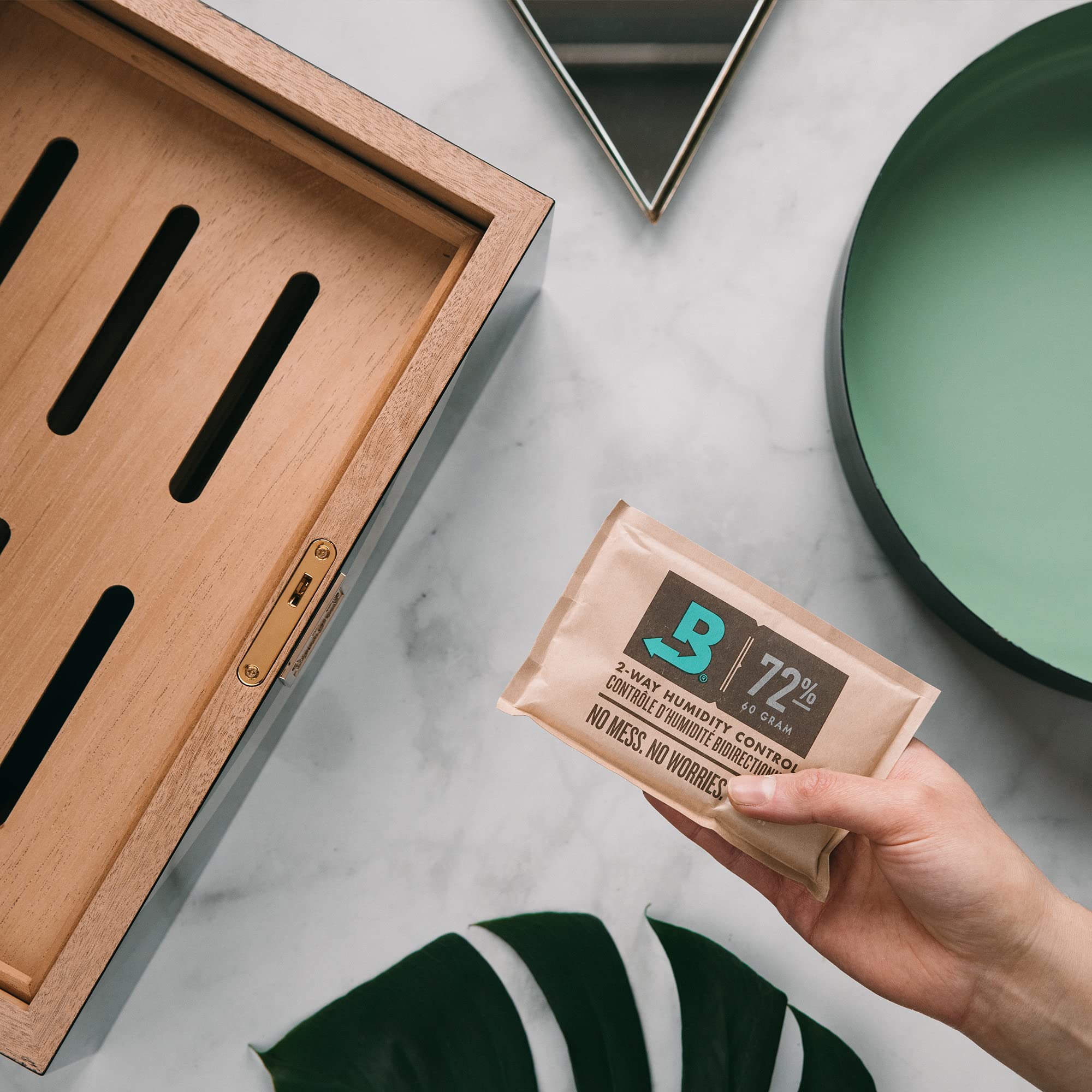 Boveda 72% pack absorbs moisture inside a wooden box protecting items.