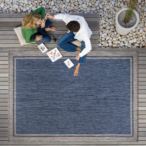 CAMILSON bordered navy rug complements garden and balcony spaces.