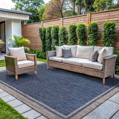 CAMILSON outdoor rug bordered navy 5x7 on patio, durable for indoor and outdoor use.