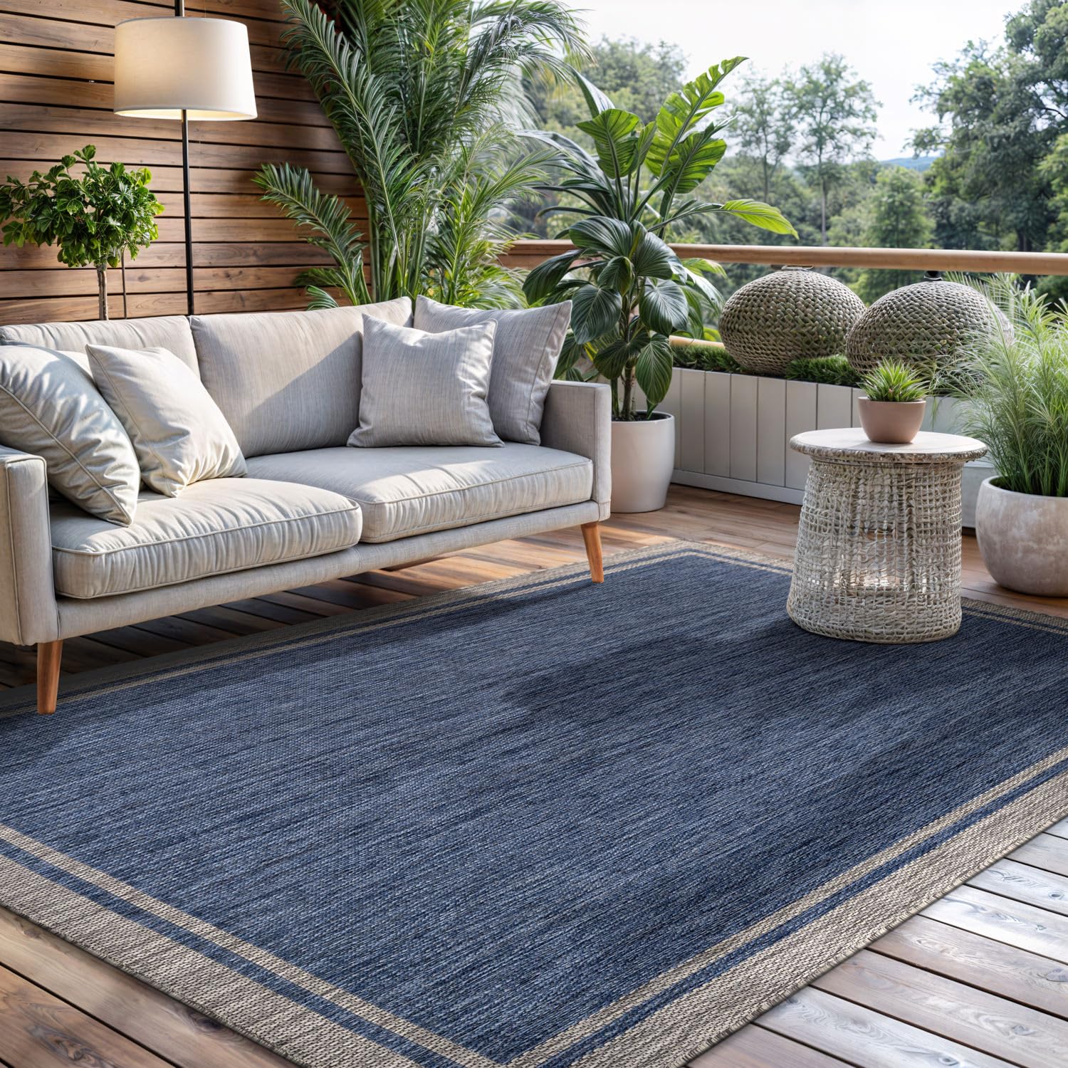 CAMILSON navy-bordered rug on a deck ready for quick vacuuming.