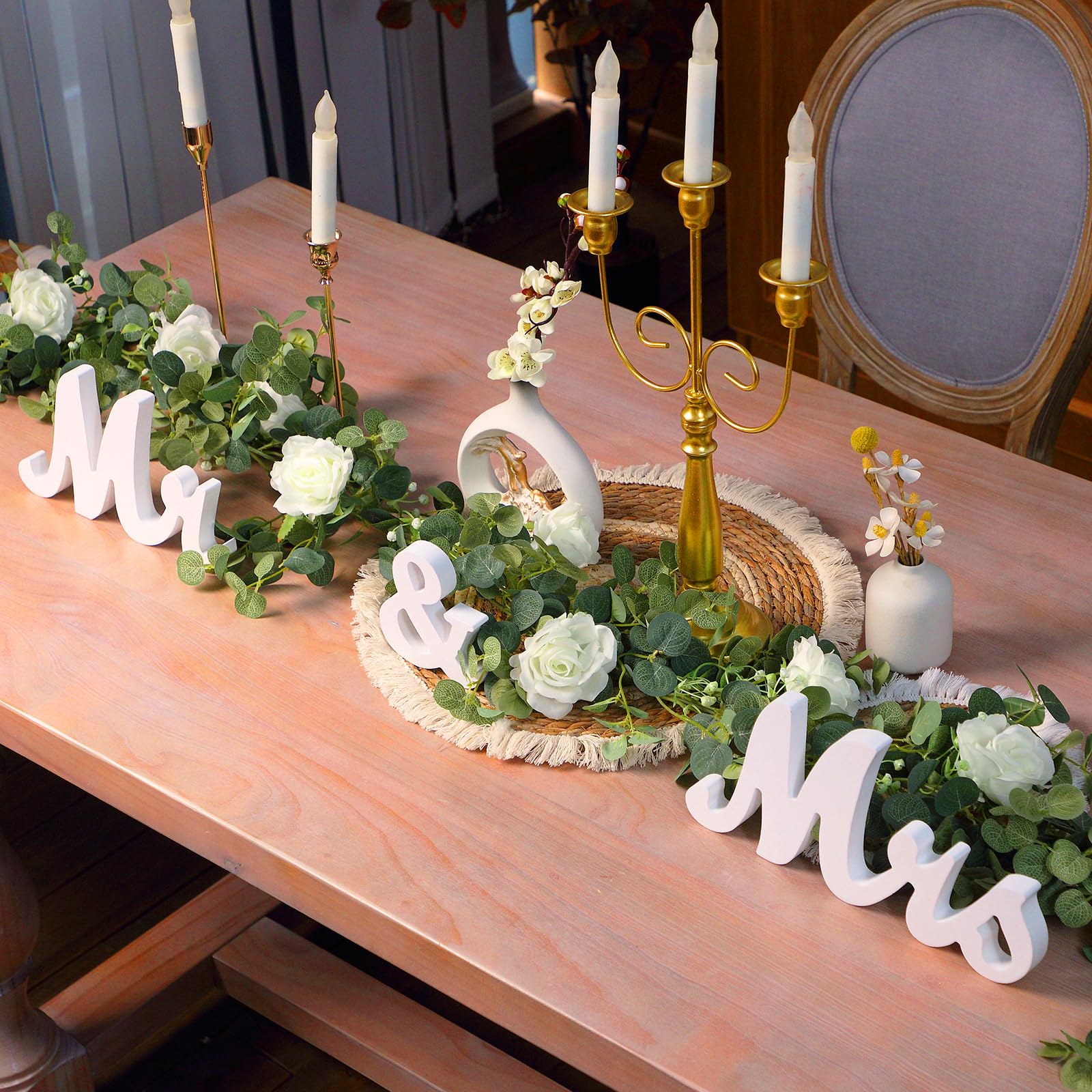 Canlierr garland with white roses enhances an elegant wedding table setup.