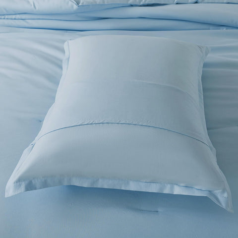 Caressma light blue comforter shown in a stylish bedroom setup for everyday use