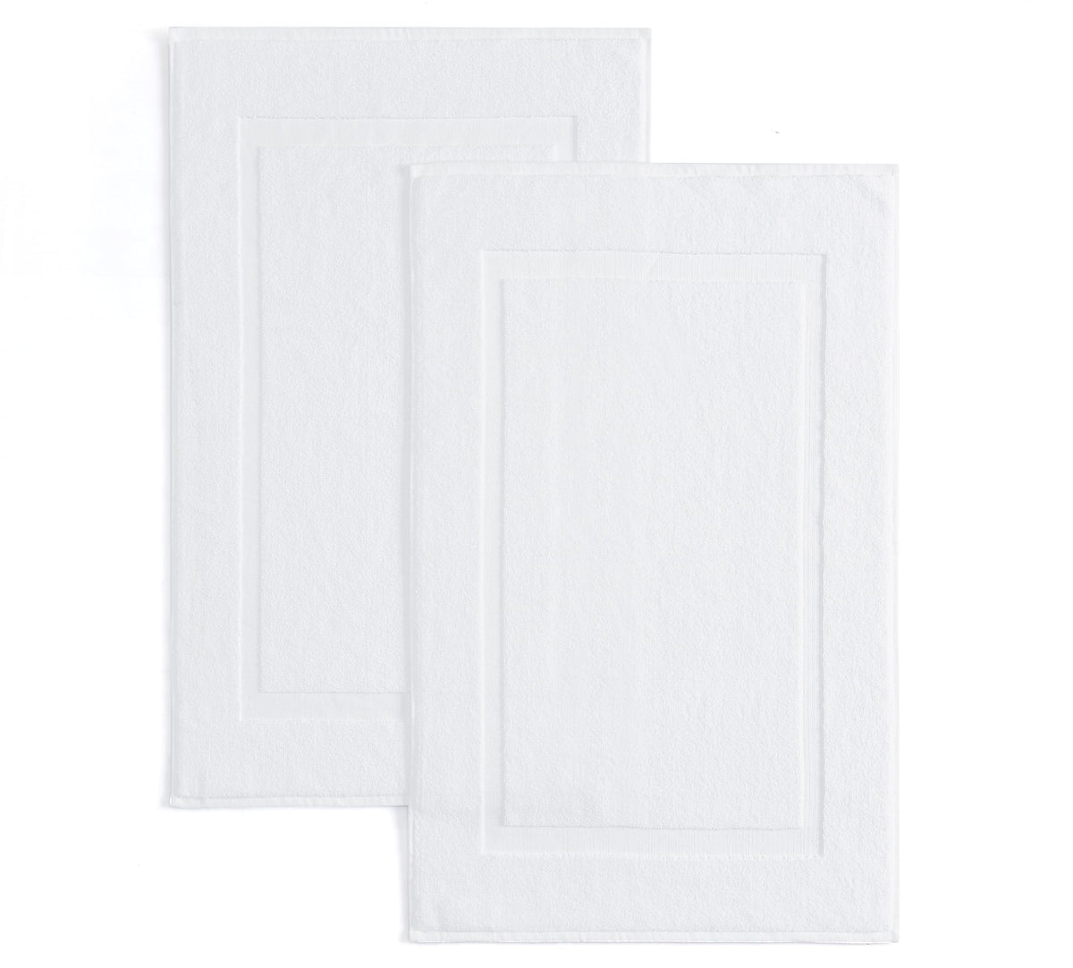 Casual Living white cotton bath mat 34x21 inches near shower for soft, absorbent comfort.