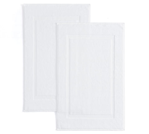 Casual Living white cotton bath mat 34x21 inches near shower for soft, absorbent comfort.