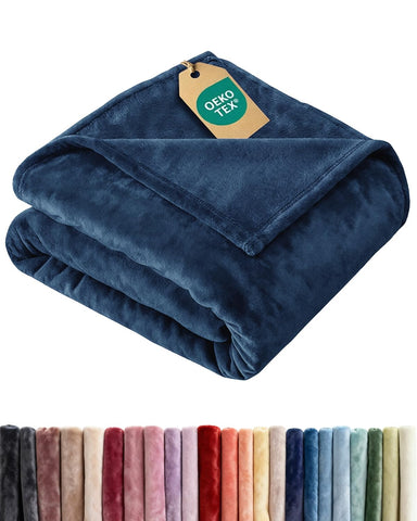CGK Unlimited ultra-soft fleece blanket folded on a bed adds cozy luxury.