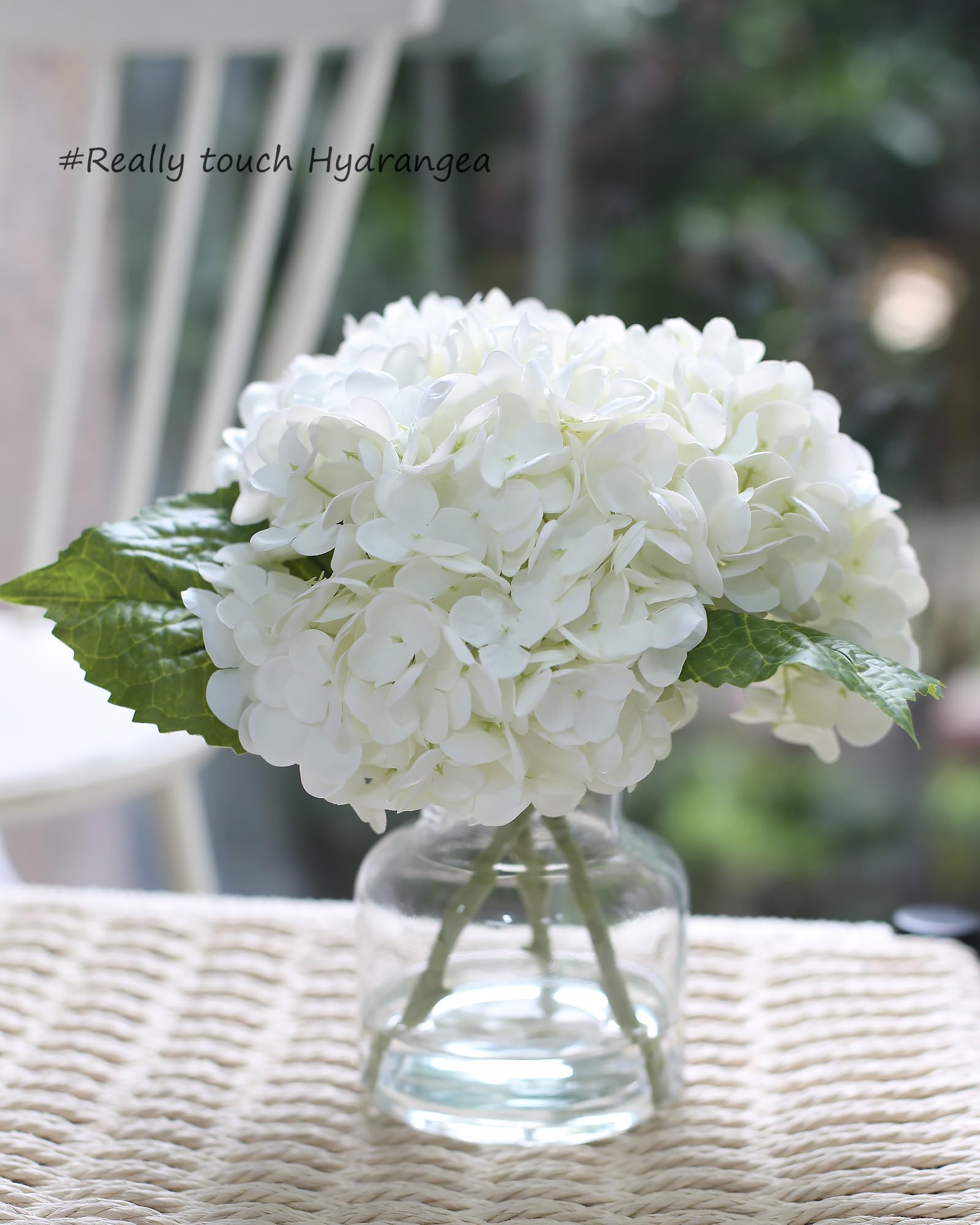 CHASMILE white hydrangea in vase shows lifelike blooms from an angled view.