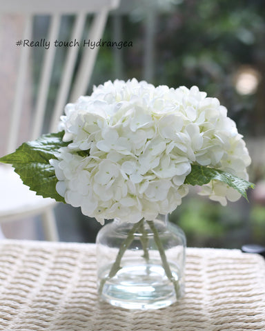 CHASMILE white hydrangea in vase shows lifelike blooms from an angled view.