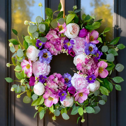 CHvista elegant front door wreath blends blush roses and purple accents for visual depth.