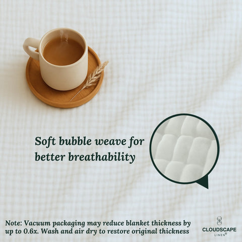 All-season Cloudscape Linen muslin blanket on a queen-size bed for year-round comfort.