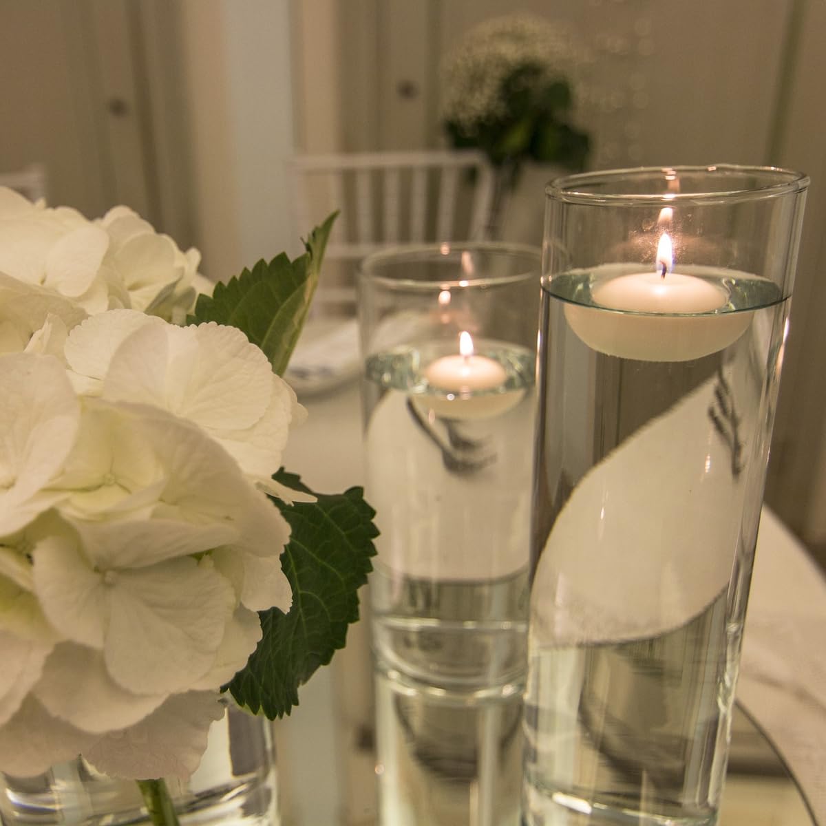 CLTNIKET white floating candle enhances vase centerpiece decor.