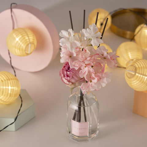 COCORRÍNA Cherry Bloom diffuser sits on living room shelf for inviting scent.